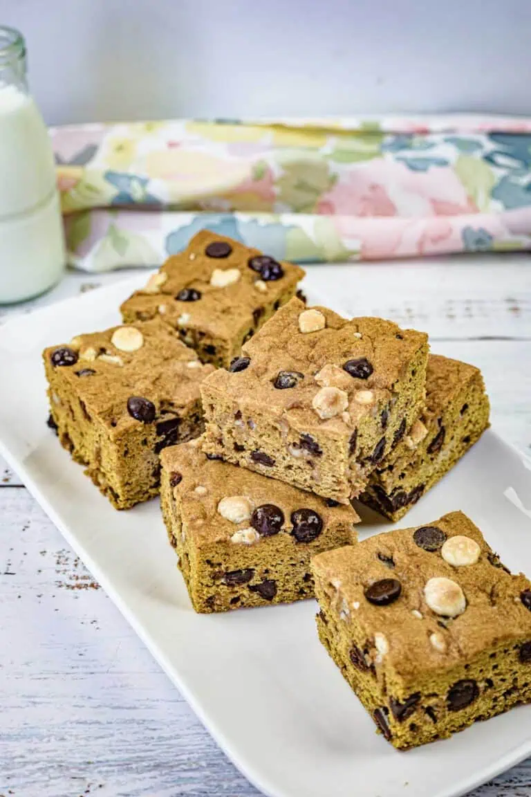 Pieces of pumpkin blondies on a white rectangular plate.