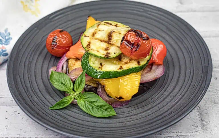Close-up shot of Grilled Ratatouille on a black plate.