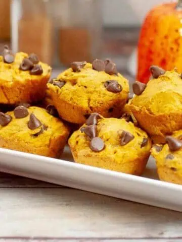 A white rectangular plate Cake Mix Pumpkin Spice Muffin topped with chocolate chips.
