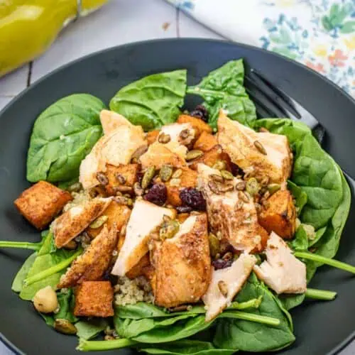 A salmon bowl served on a black plate.