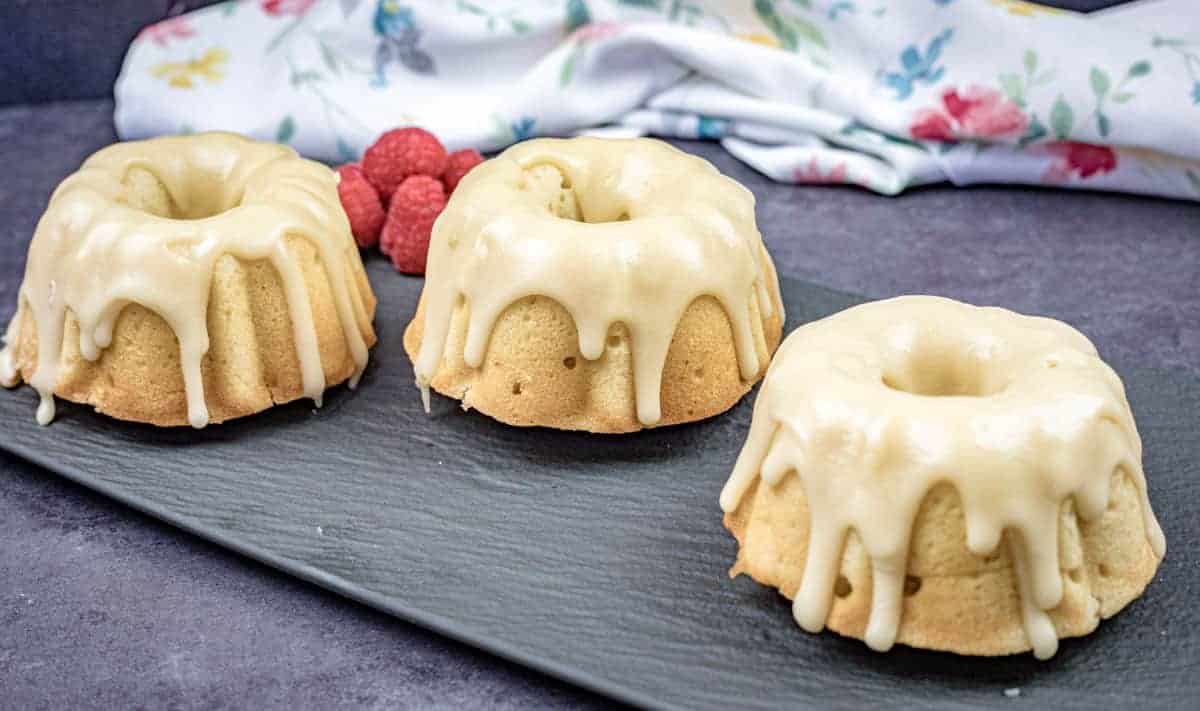Three mini bundt Buttermilk Cake with Brown Sugar Glazes on a slate platter.