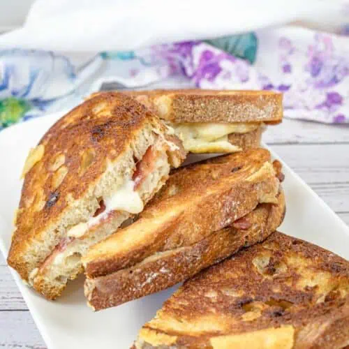Bacon Grilled Cheese Sandwiches with Hot Honey Butter on a white plate.