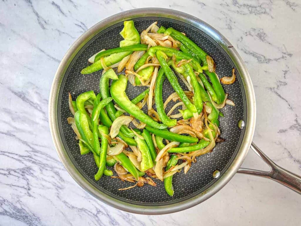 Sauté onions until caramelized, then add green bell pepper.