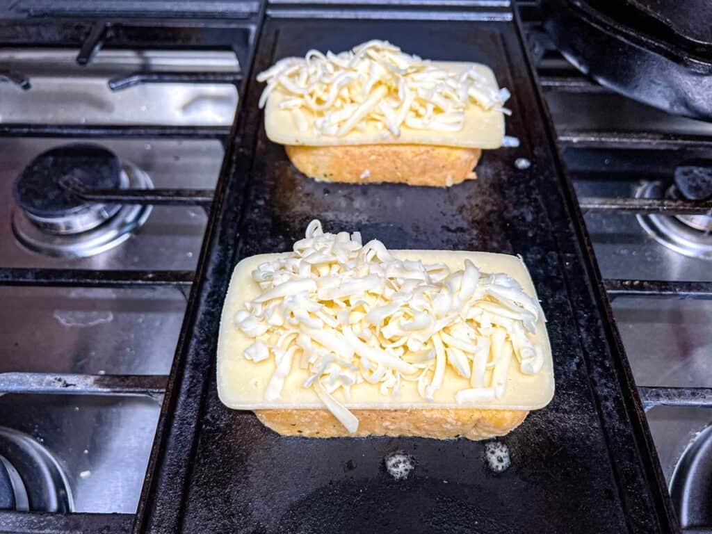 Sprinkle about &frac14; cup of shredded mozzarella evenly on the sliced cheese.
