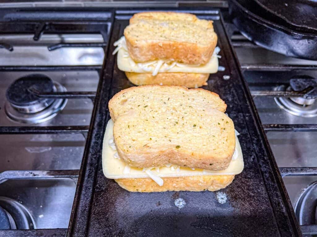Top each sandwich with another slice of garlic bread.
