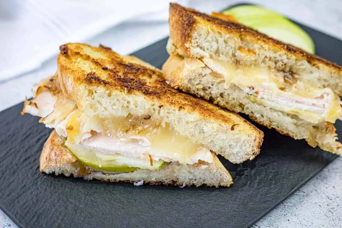 Turkey & Apple Grilled Cheese displayed on a slate plate.