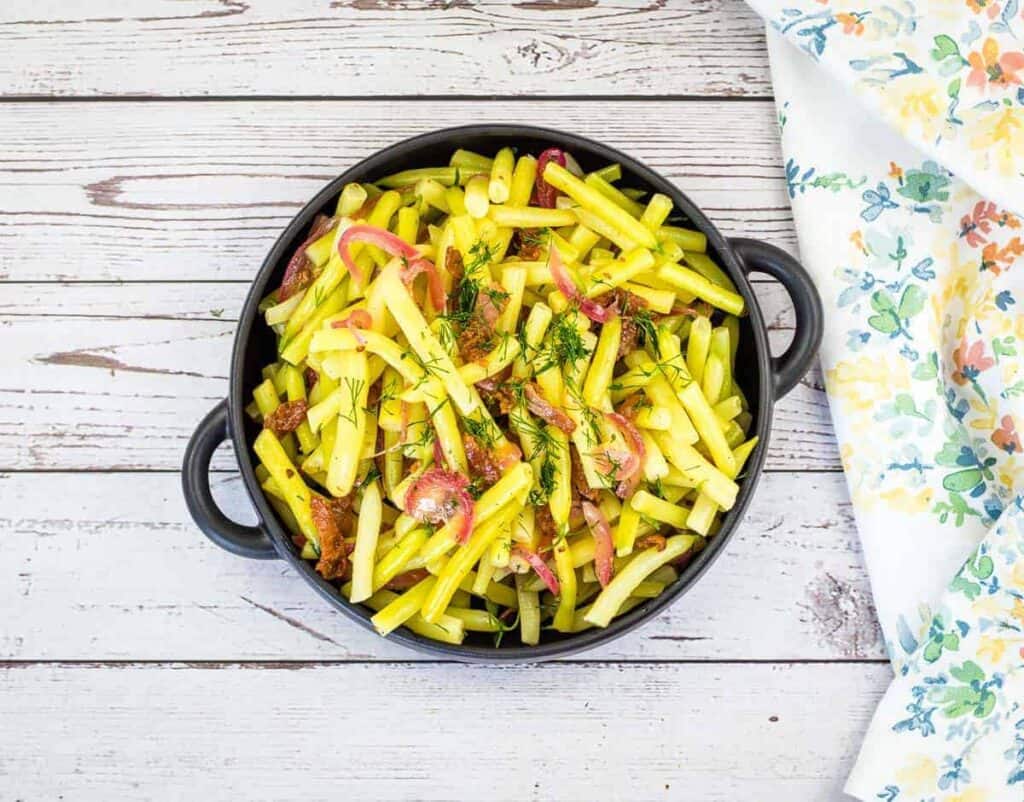 A bowl of German yellow beans on a wooden table.