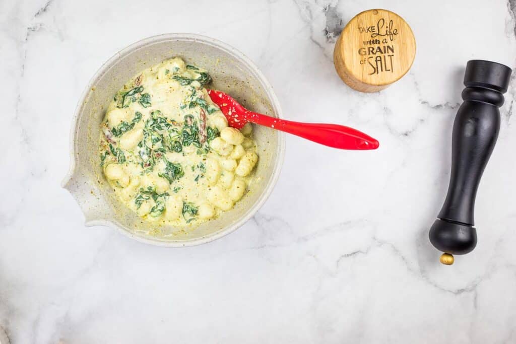 Toss the gnocchi, then transfer the mixture to a casserole dish.