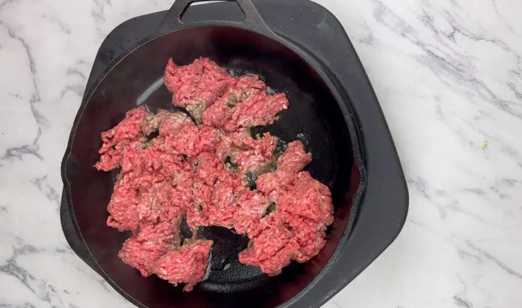 Cook the ground beef over medium heat.