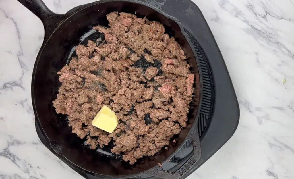 Drain any excess fat and add half the butter.