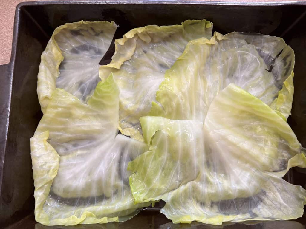 Layer the cabbage leaves in the baking dish to cover the bottom.