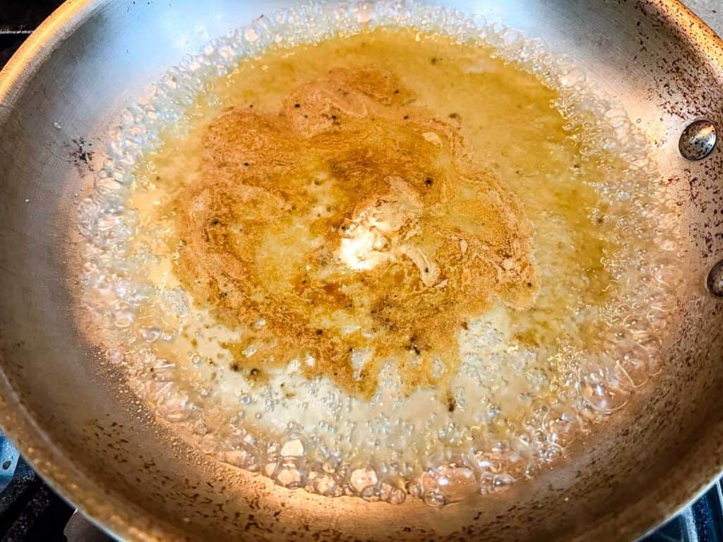Deglaze the skillet by pouring in the white wine.