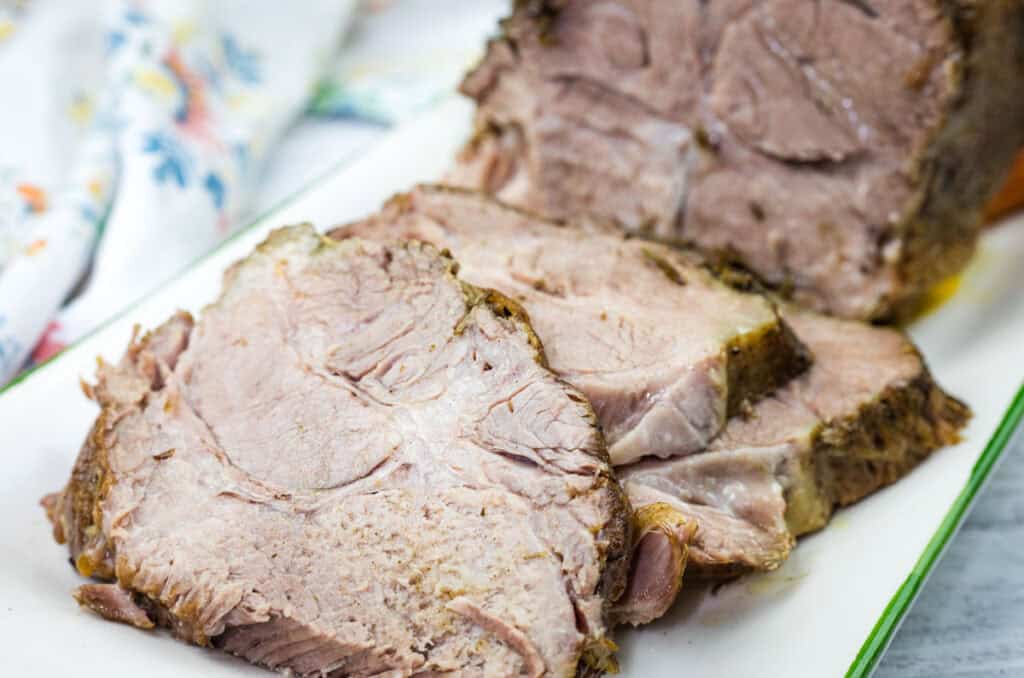 Slices of Slow Cooker Herb-Crusted Pork Roast on the plate.