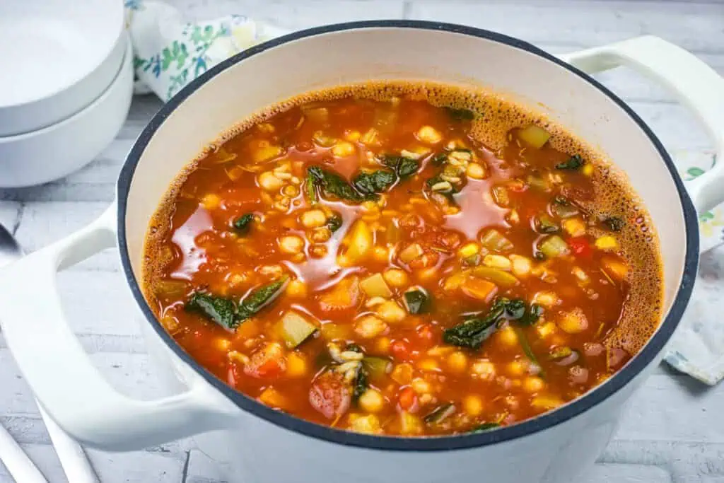 A white pot filled with Copycat Panera Bread’s Vegan 10 Vegetable Soup.