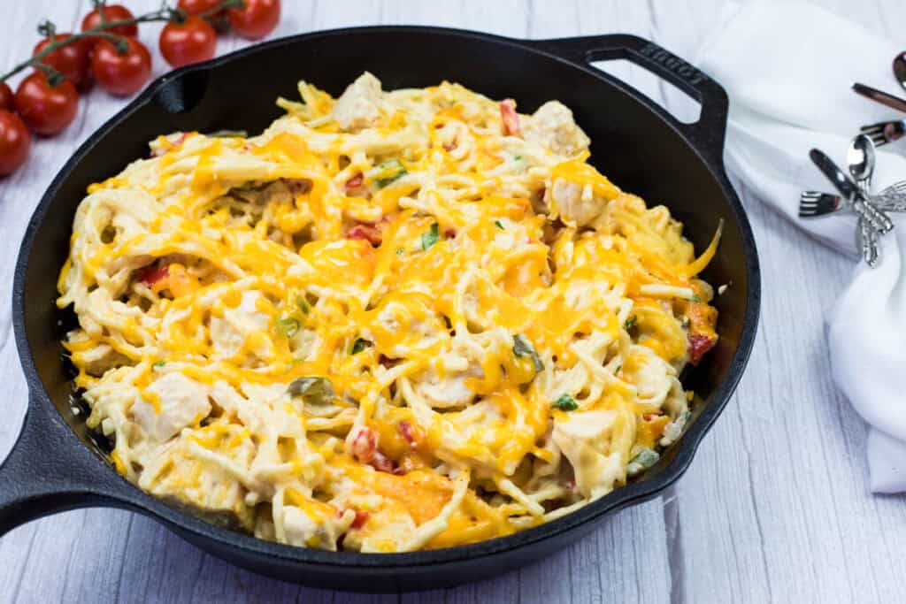 A serving of chicken spaghetti from a cast-iron skillet.