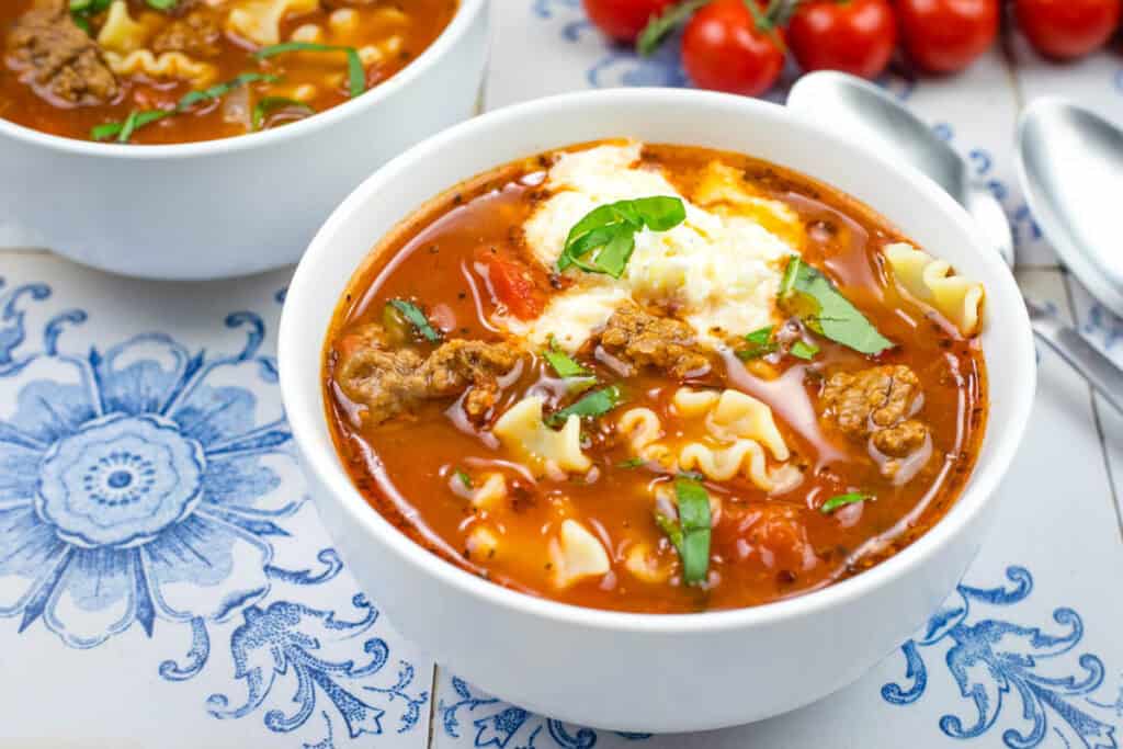 A bowl of Lasagna Soup topped with chopped basil.