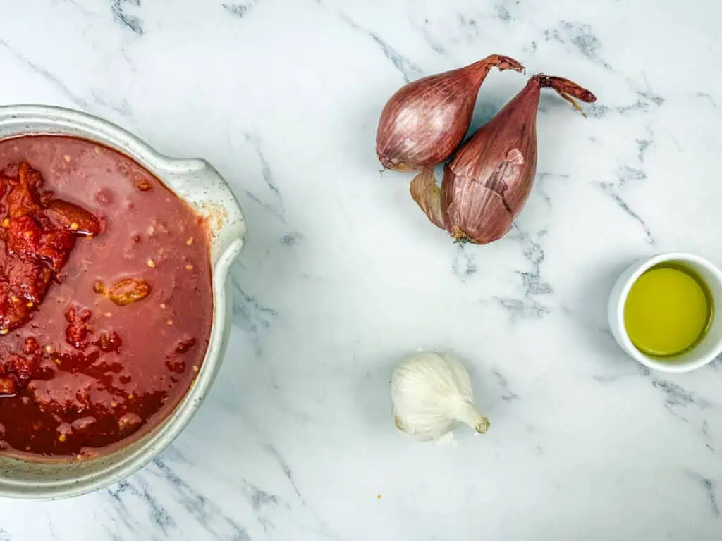 Ingredients for the sauce of Ricotta Meatballs with Tomato Sauce on the table.