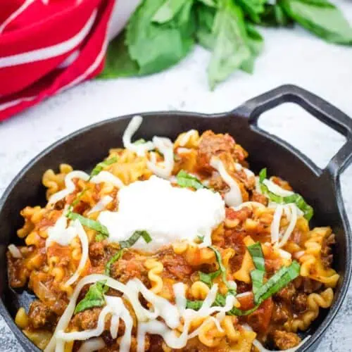 A serving of skillet lasagna in a black bowl.