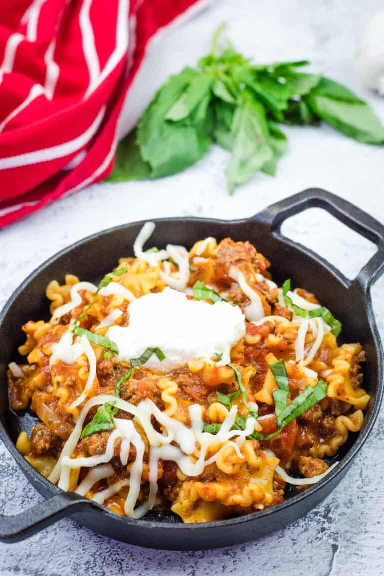 A serving of skillet lasagna in a black bowl.