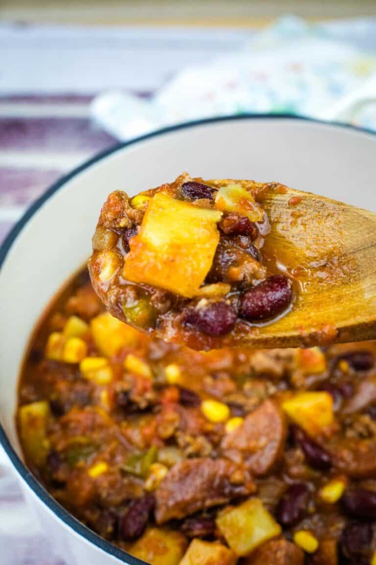 A wooden spoon with a Texas Cowboy Stew from a casserole.