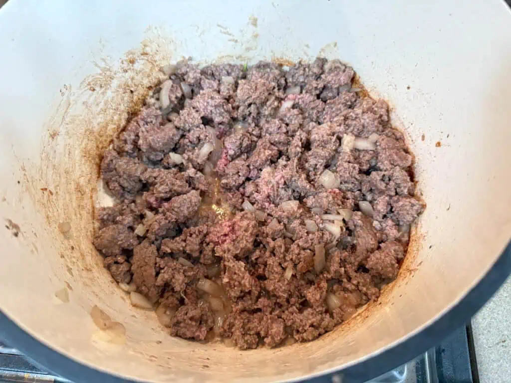 A bowl of ground beef, garlic, and other spices mixture.