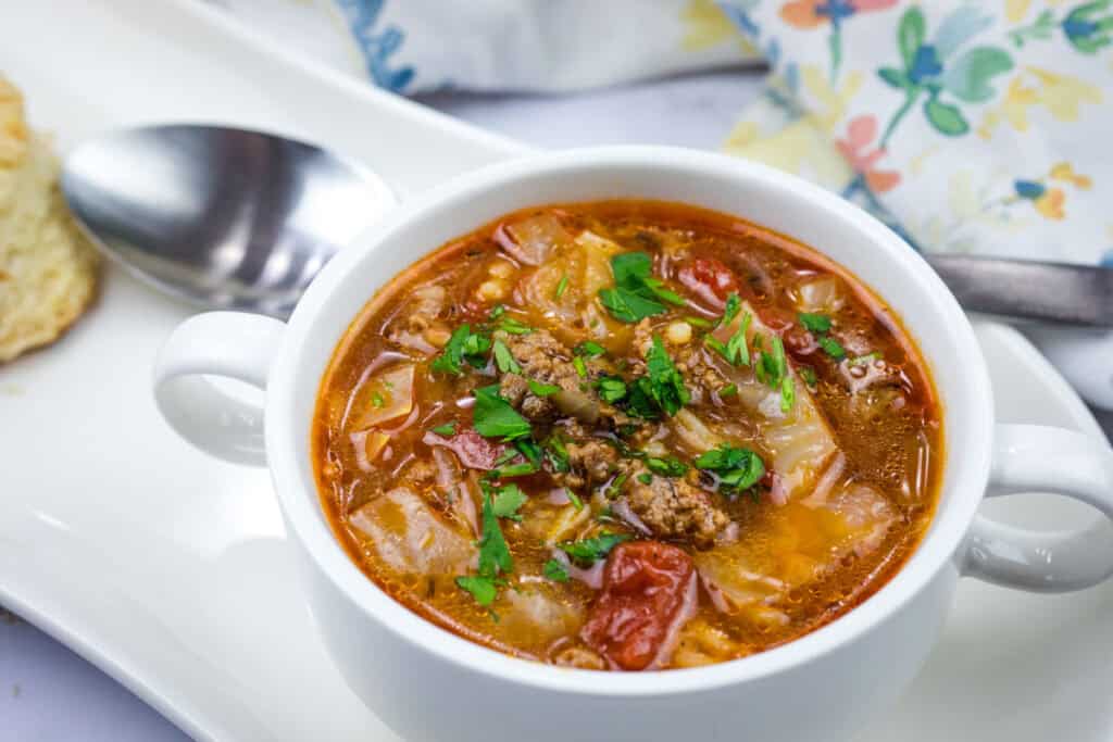 A bowl of cabbage roll soup garnished with parsley.
