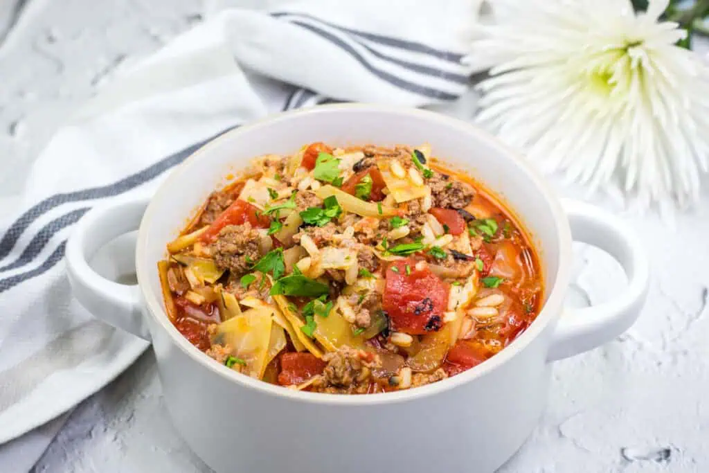 A delicious cabbage roll soup in a white bowl.