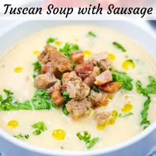 A white bowl of Creamy Tuscan Soup With Sausage & Kale.