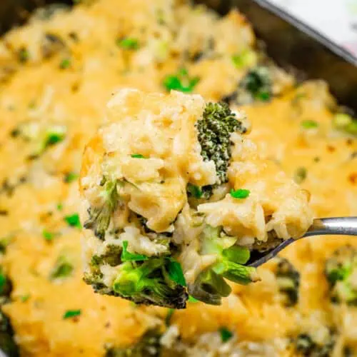 A spoonful of Broccoli Rice Casserole with Fresh Broccoli, with melted cheese, tender broccoli, and rice, garnished with fresh herbs.