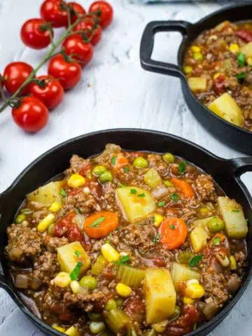 Two cast iron pans filled with a Vintage Hamburger Stew.