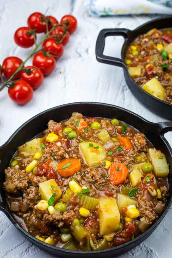 Two cast iron pans filled with a Vintage Hamburger Stew.