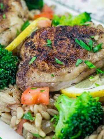 Lemon Chicken Broccoli Orzo Skillet, diced tomatoes, lemon slices, and parsley garnish.