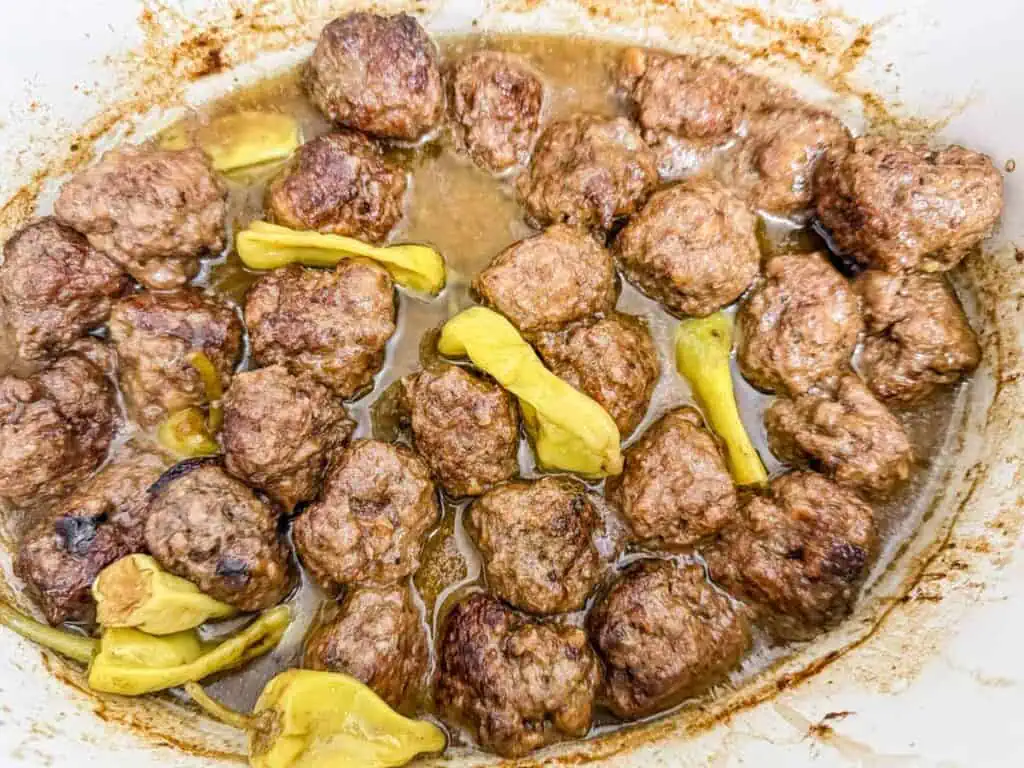 Slow-cooked Mississippi meatballs in a rich, savory sauce with pepperoncini peppers, ready to be served.