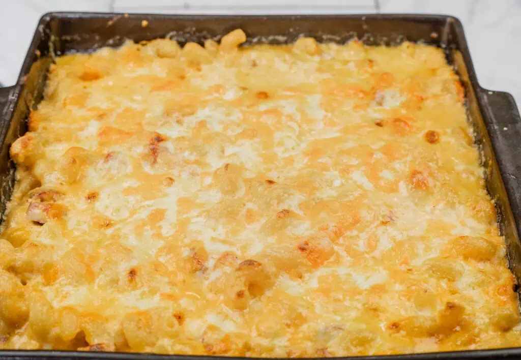 Baked macaroni and cheese in a rectangular dish with a golden, bubbly cheese topping.