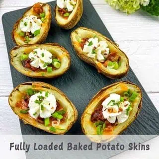 A vertical shot of Baked Potato Skins on a black platter.