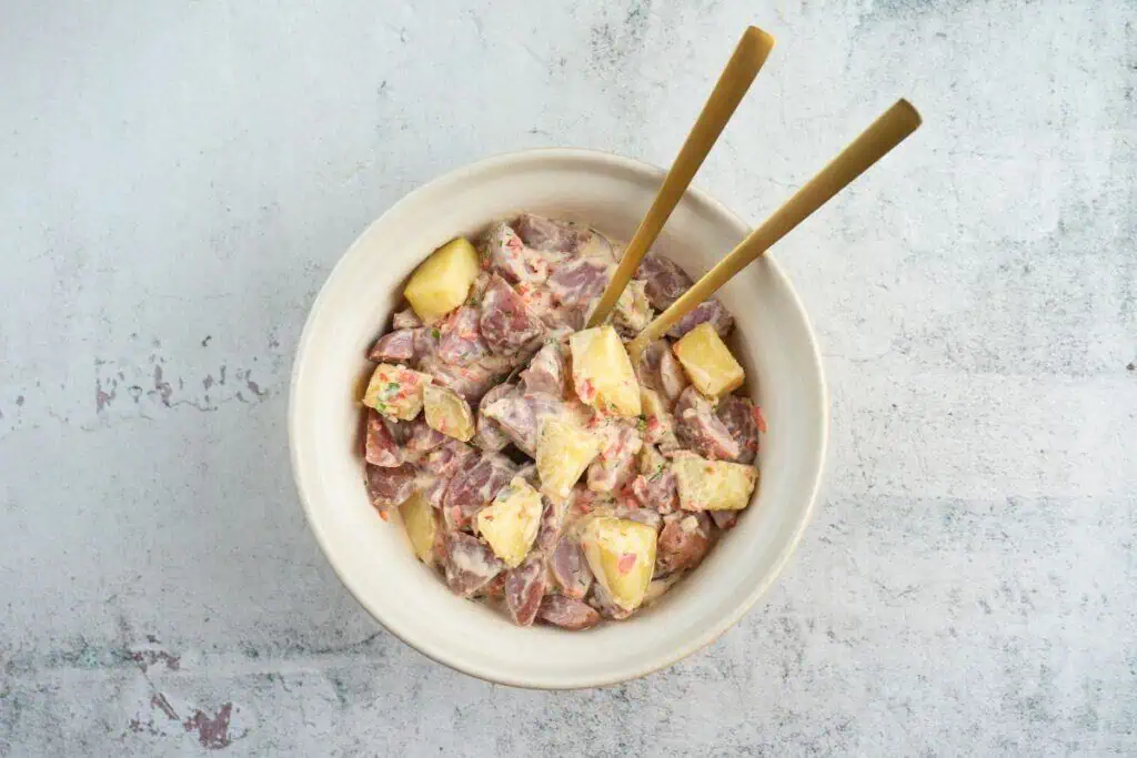 Pouring dressing on potatoes. 