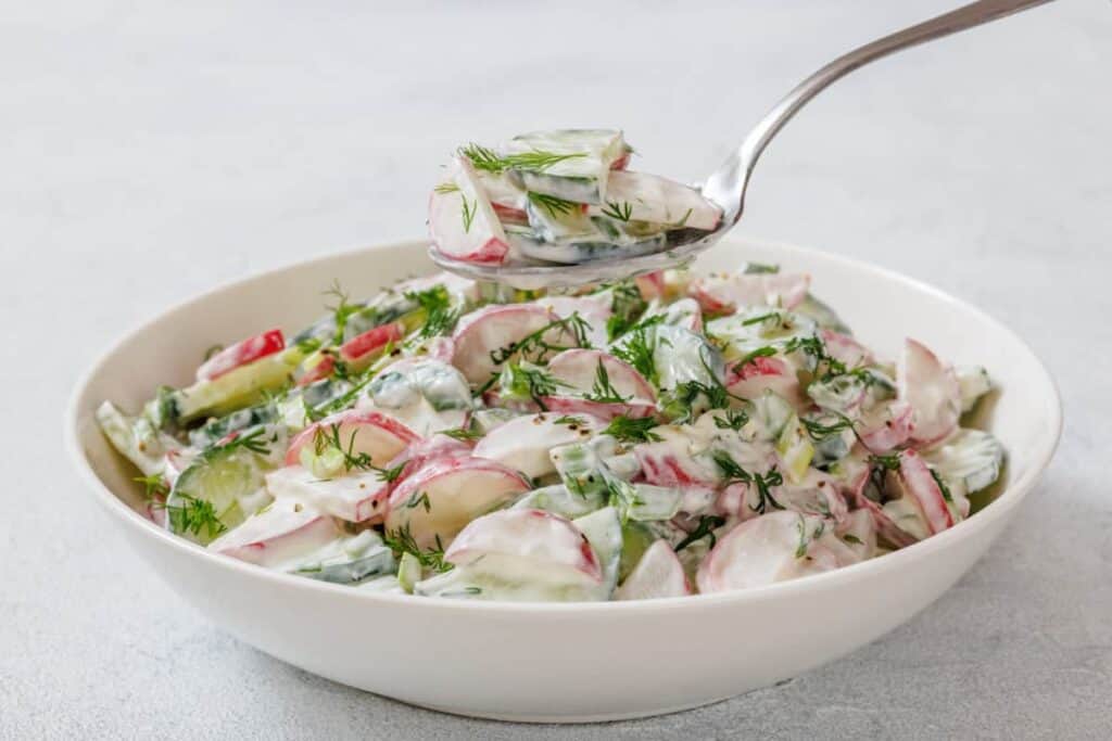 Creamy Radish Salad on a white bowl.
