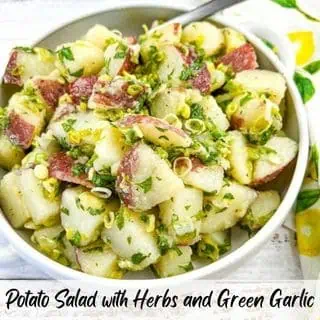 Potato Salad with Herbs & Green Garlic in a white serving bowl.