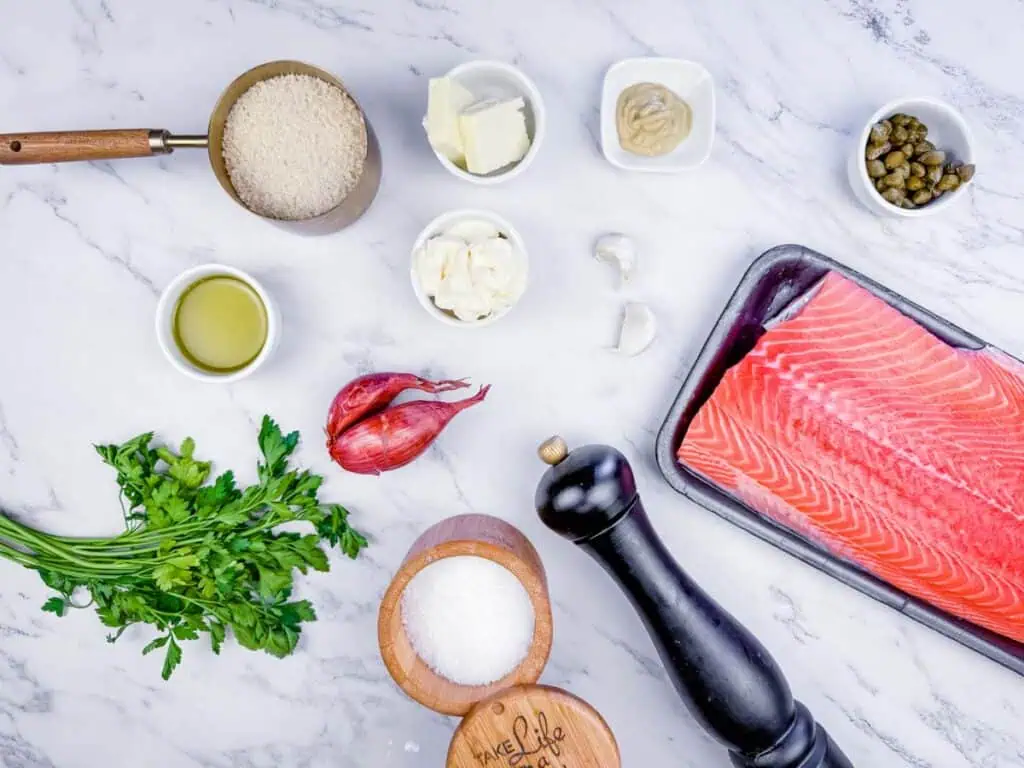 Overhead shot of ingredients for broiled salmon with a chermoula herb crust, including a salmon fillet, herbs, spices, and other flavorings.