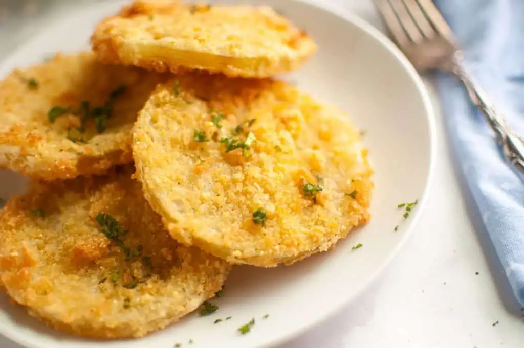 A plate of fried potatoes with a fork and knife.