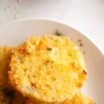 A white paper plate with several fried green tomatoes.