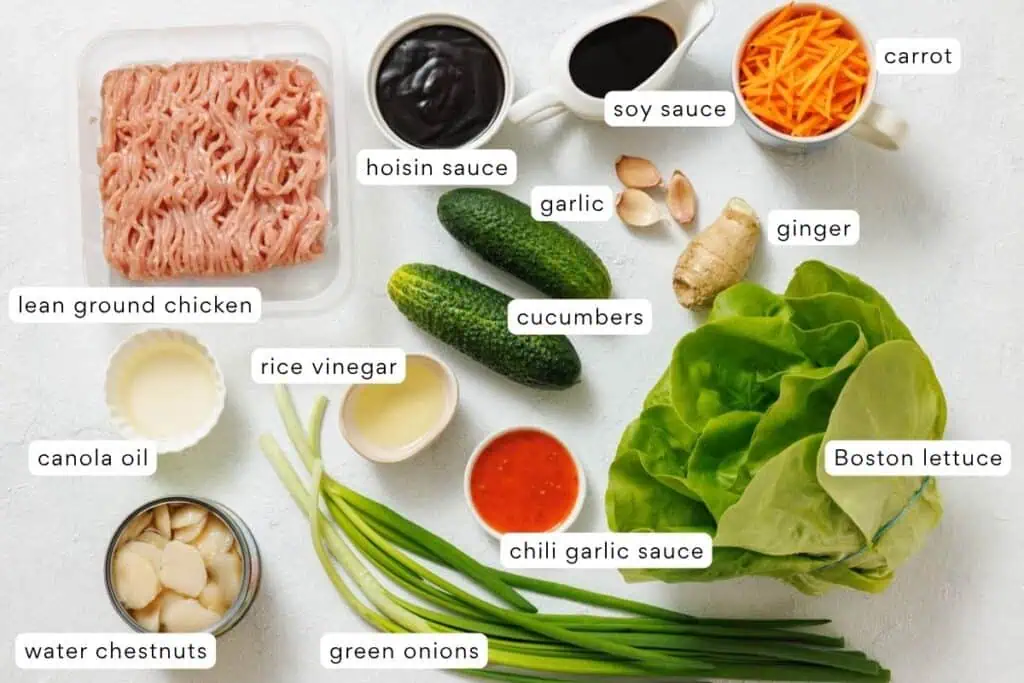 Ingredients for a lettuce wrap on a white surface.