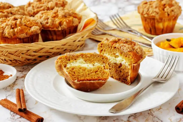 Pumpkin spice muffins with a slice cut out.