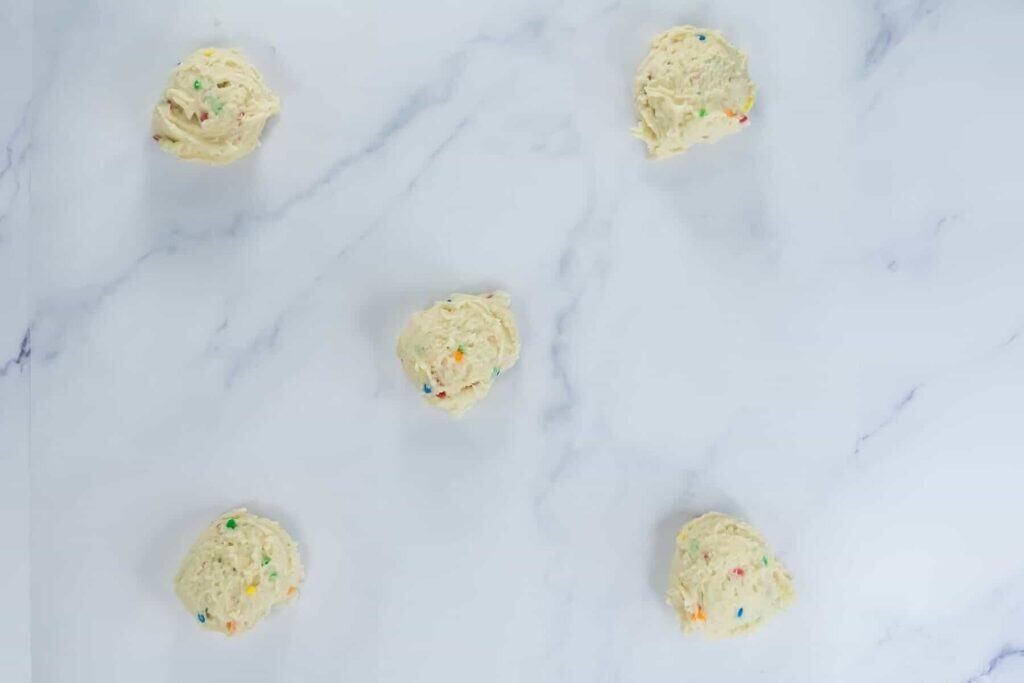 Dough portions on marble surface.