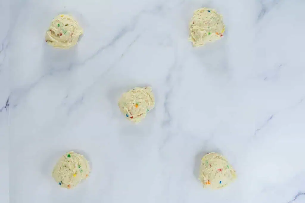 Dough portions on marble surface.