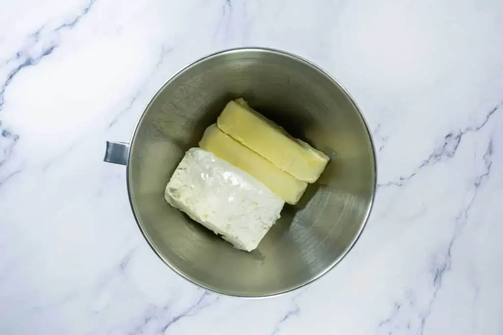 A metal bowl filled with butter and cheese.
