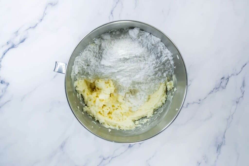 A bowl of butter and flour on a marble counter.