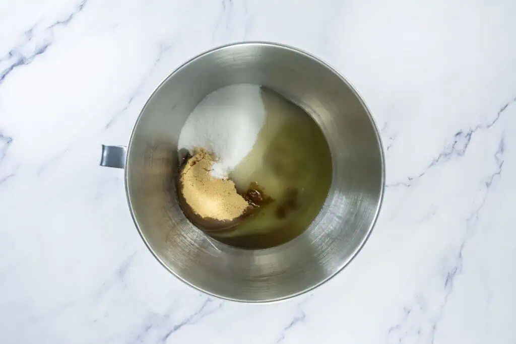 Mixing bowl with white sugar, brown sugar, and oil, ready to be mixed.