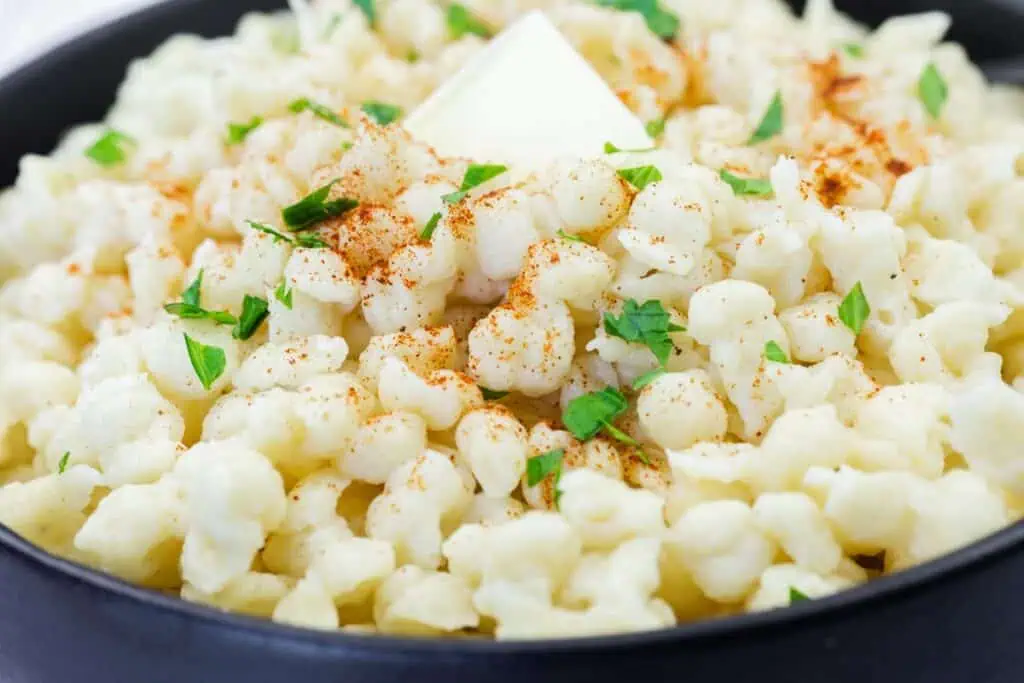 Close-up shot of Spaetzle on a black dish.