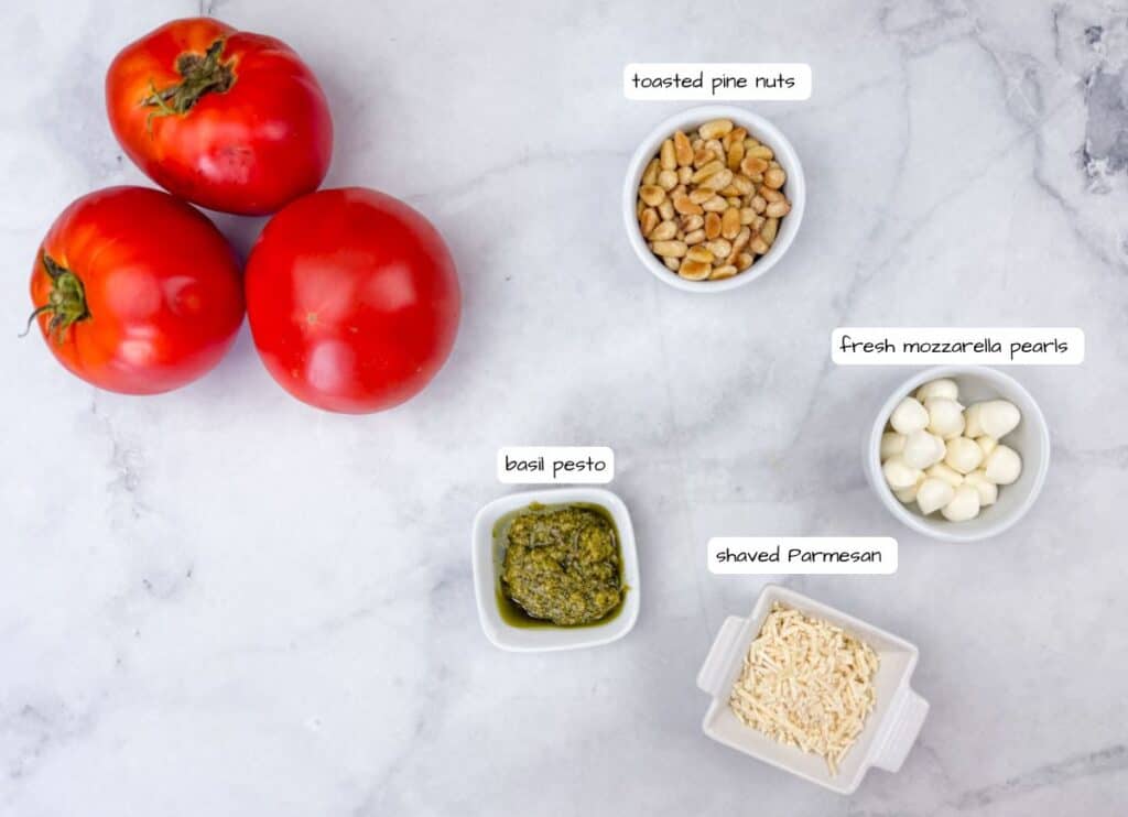 Tomatoes and nuts in bowls with pesto and mozzarella cheese.